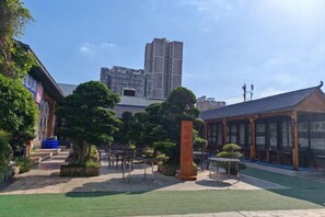 A courtyard with traditional architecture, a building with a tiled roof, and a tall structure in the background. - Jialong Hotel (Guangyuan High-speed Railway Station) (Guangyuan)