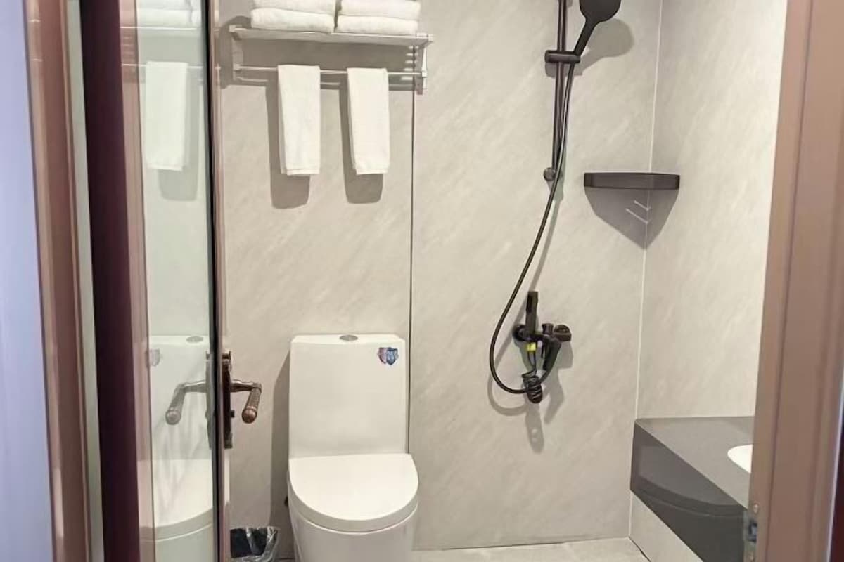 Une salle de bain avec des toilettes, une douche et un lavabo.