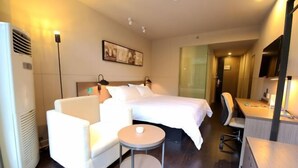 Una habitación de hotel con cama, sofá, escritorio y una silla.