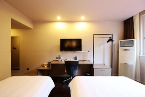 A hotel room with two beds, a desk with a chair, a TV mounted on the wall, and an air conditioning unit. - Jinjiang Inn Select (Lushan City)