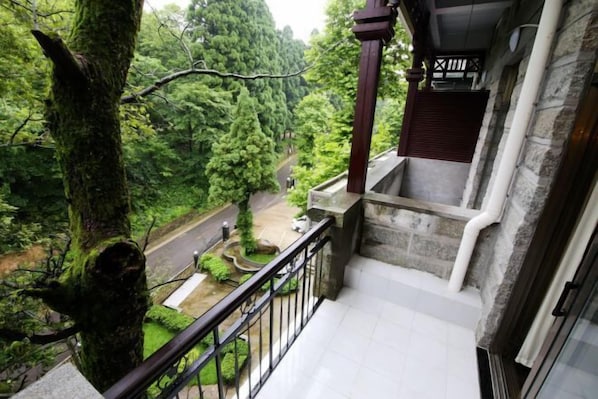 A stone staircase leading to a covered area with a view of a road and greenery. - Jinjiang Inn Select (Lushan City)