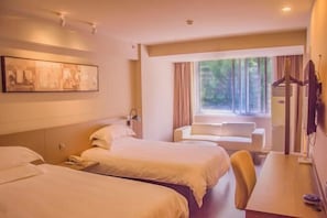 A hotel room with two beds, a desk, a chair, a window with curtains, and a wall-mounted TV. - Jinjiang Inn Select (Lushan City)