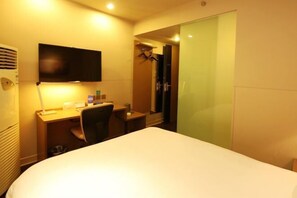 A hotel room with a bed, a desk, a chair, a television, and a shower area. - Jinjiang Inn Select (Lushan City)