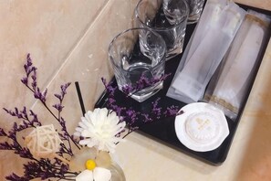 A tray with a glass, napkin, and a white object on a tiled surface. - Huating Hotel (Mojiang)