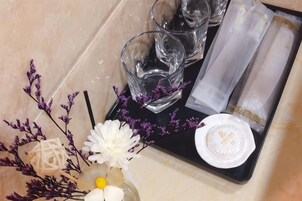 A tray with a glass, napkin, and a white object on a tiled surface.