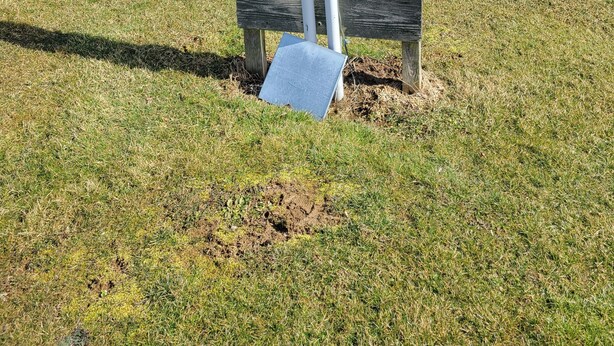 A utility box mounted on a wooden post in a grassy field. - Pondside Campground (Meadville)