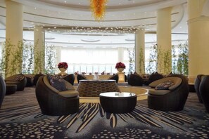 A spacious lobby with a central seating area, large windows, and decorative plants. - Island International Hotel (Liupanshui)