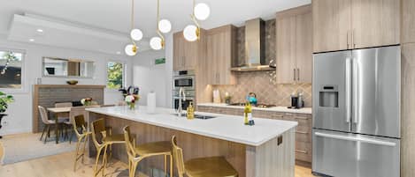 A modern kitchen with a central island, stainless steel appliances, and wooden cabinetry.