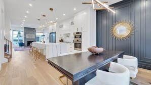Une cuisine moderne avec des meubles blancs, un plan de travail foncé et une décoration murale originale.