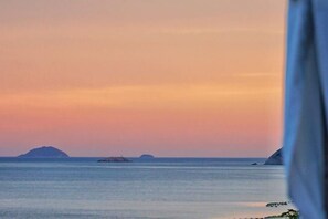 A coastal view with calm waters and distant islands during sunset. - Qingdao Qigu Abalone Island No.85 Homestay (Qingdao)