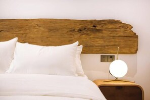 A bed with white bedding, a wooden headboard, and a bedside table with a round lamp. - Qingdao Qigu Abalone Island No.85 Homestay (Qingdao)