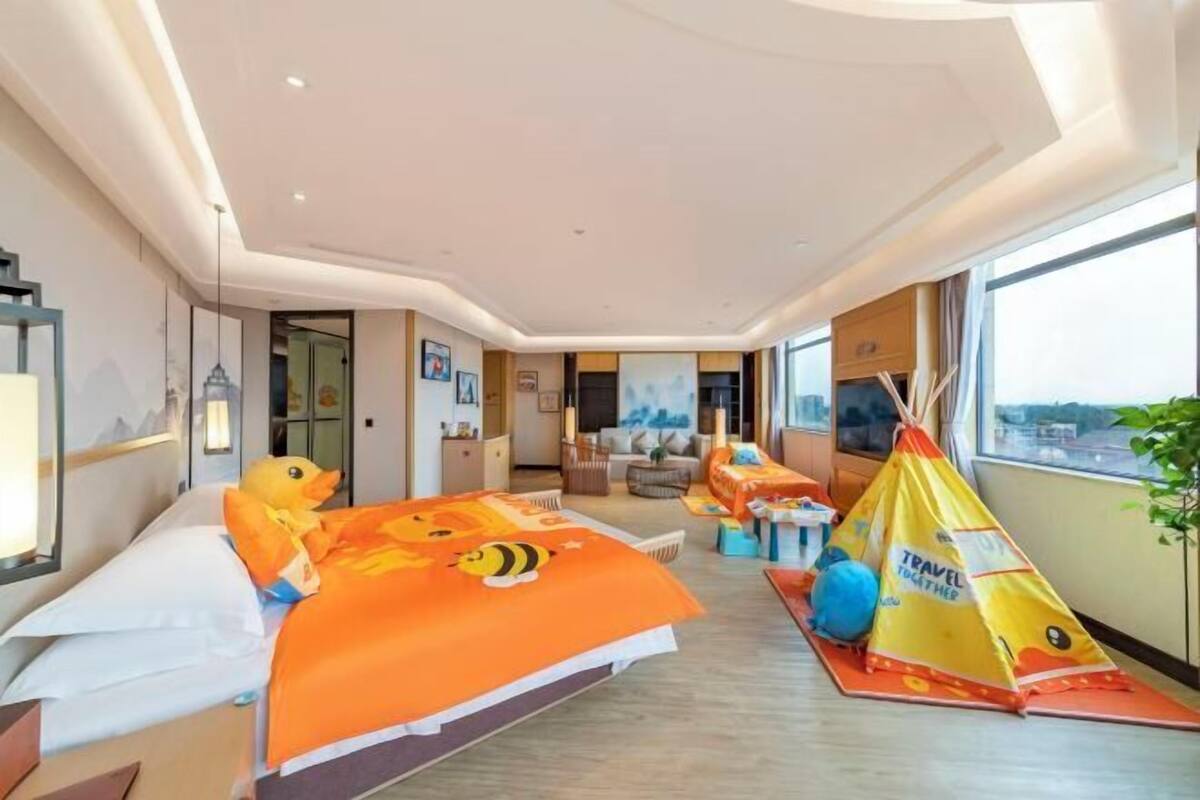Een hotelkamer met een bed, een bank, een raam en een tent.
