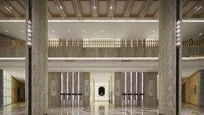 A spacious lobby with a high ceiling, marble flooring, and a central open space leading to a lower level. - Haitian Yongxin Hotel (Qionglai)