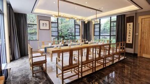 A spacious room with a long wooden table and chairs, large windows with a view of greenery, and a polished marble floor. - Haitian Yongxin Hotel (Qionglai)