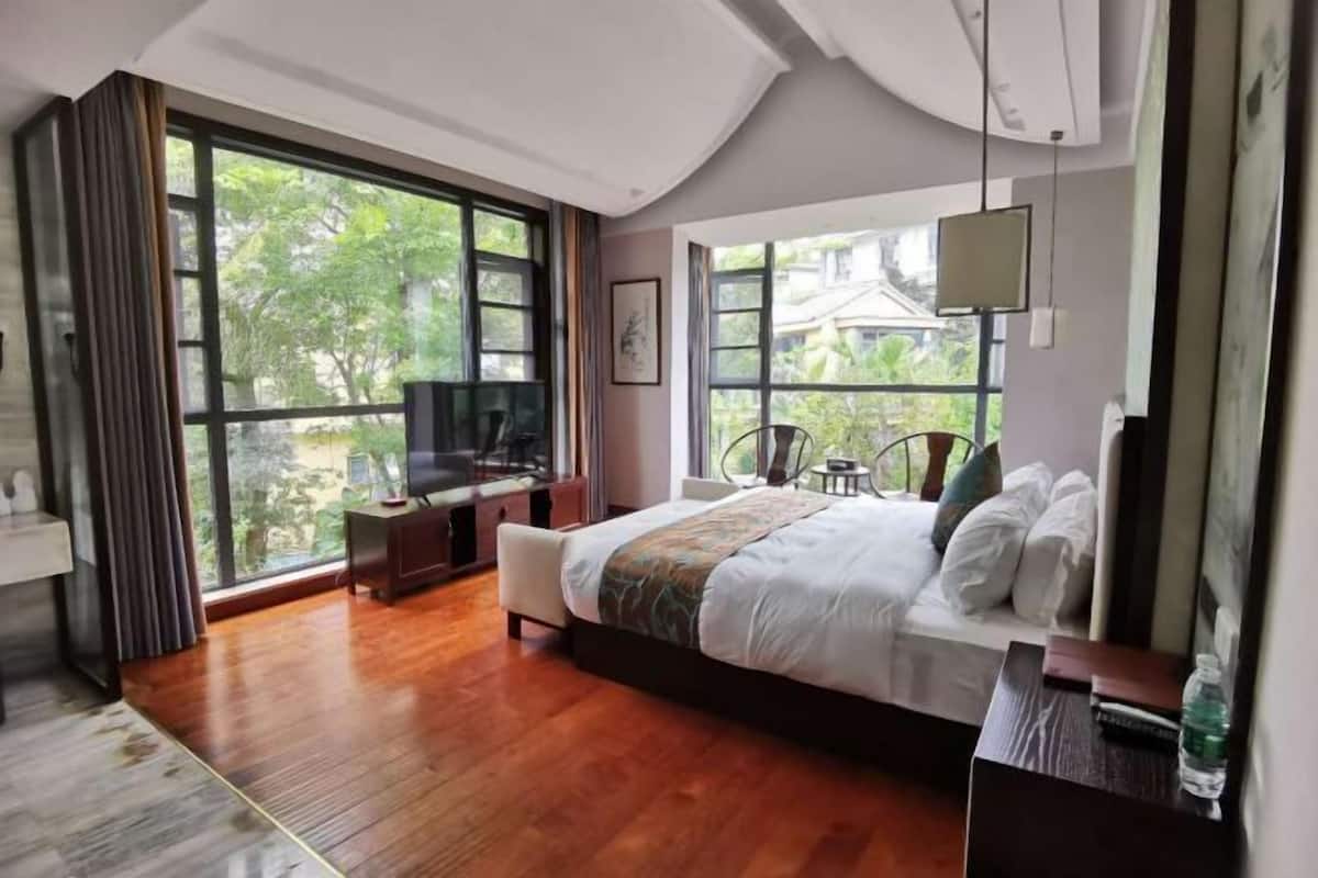 Een moderne hotelkamer met een groot bed, een bureau en een televisie.