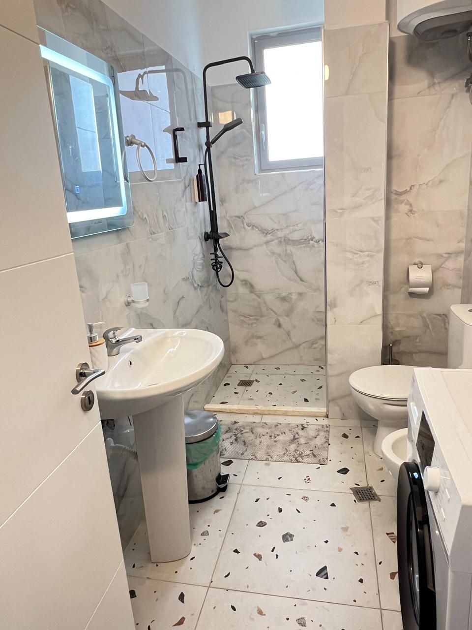 A bathroom with a shower, toilet, and sink.
