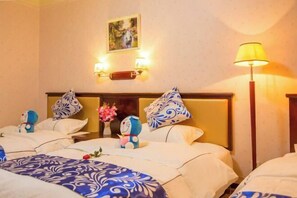 A hotel room with two beds, each with a blue and white patterned bedspread, a wooden headboard, and decorative pillows. There is a wall-mounted light fixture and a floor lamp. - Yageba Hotel (Lijiang)