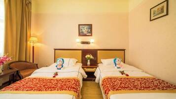 A hotel room with two beds, a nightstand with a lamp, a framed picture on the wall, and a window with curtains.