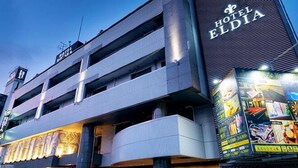 Um hotel de vários andares com uma placa visível que diz 'Hotel Eldia'.