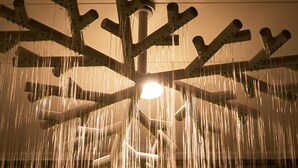 Uma fonte com vários jatos de água, uma fonte de luz central e uma estrutura no teto.