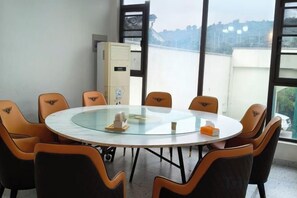 A conference room with a round table and chairs, large windows, and a view of the city. - Carefree Valleys (Suzhou Qiyuan Road Store) (Suzhou)