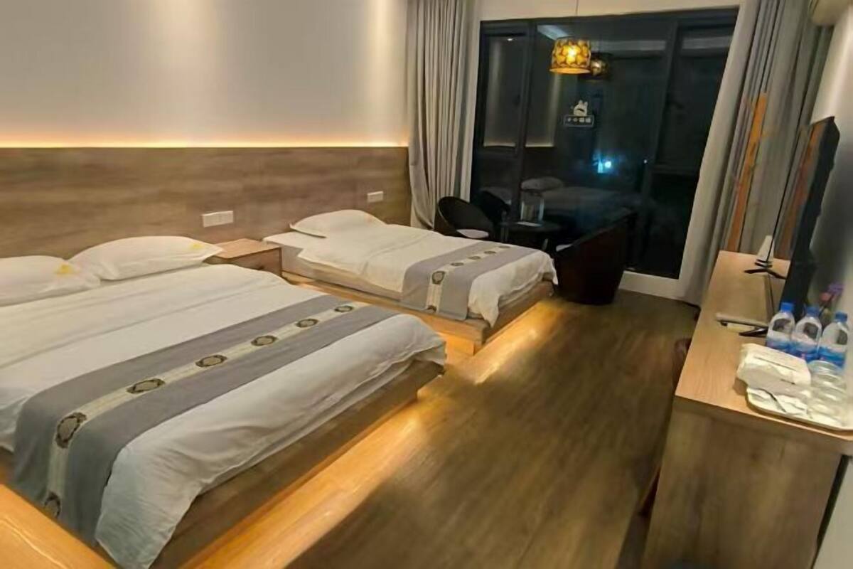 Une chambre d’hôtel avec deux lits, un bureau et une chaise.