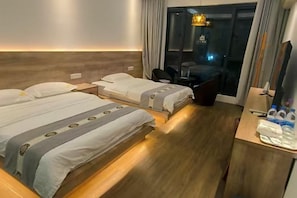 Ein Hotelzimmer mit zwei Betten, einem Schreibtisch und einem Stuhl.