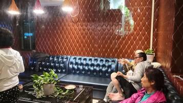 A room with a blue leather sofa, a potted plant, and a table with a decorative item.