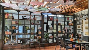 Un coin lecture chaleureux avec des étagères à livres, des sièges confortables et des parapluies décoratifs.