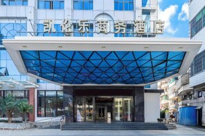 A hotel entrance with a modern design, featuring a glass facade and a geometric pattern on the roof. - Wanning Kailunle Business Hotel (City Center) (Wanning)