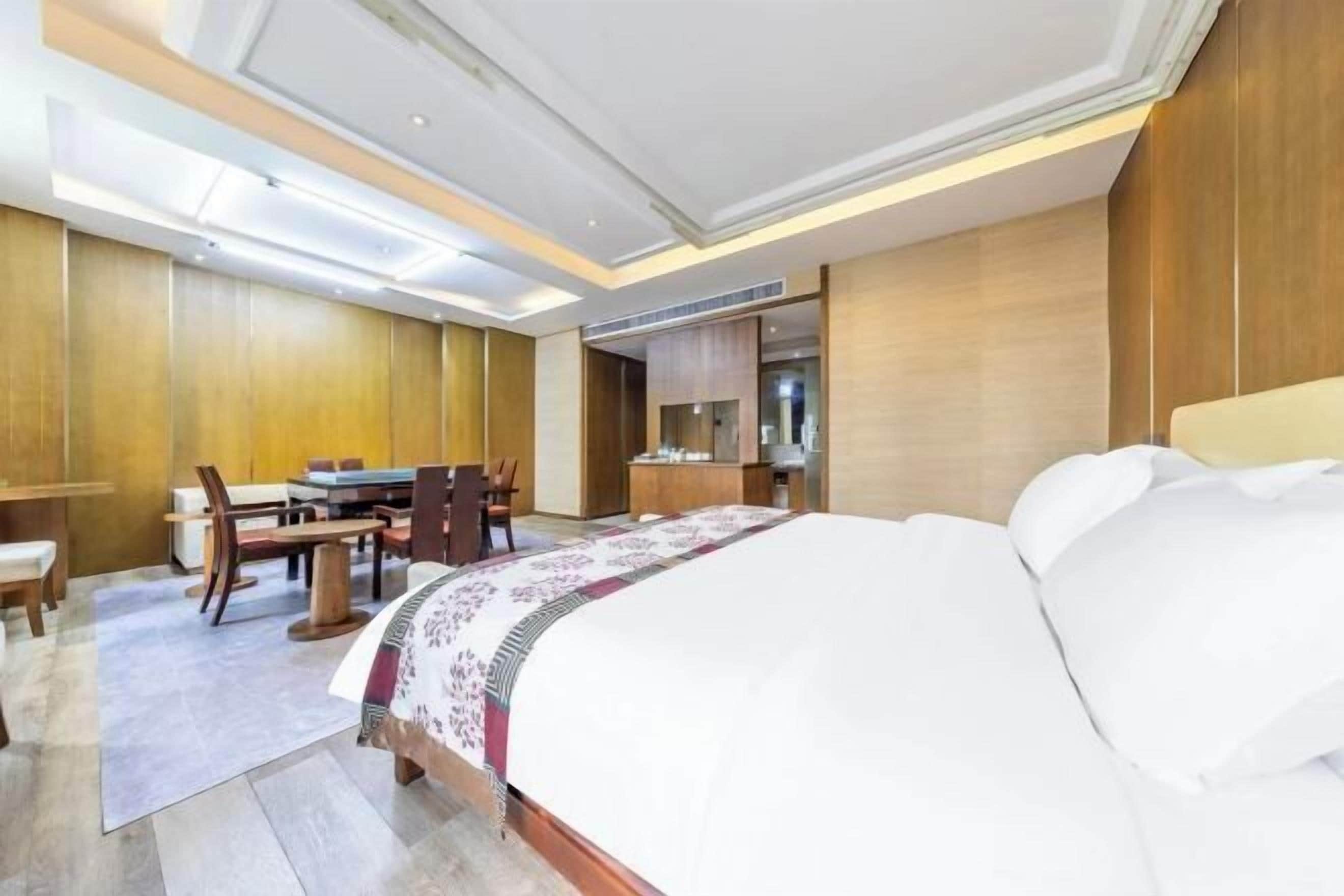 Een moderne hotelkamer met een groot bed, een bureau en een zithoek.