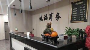 A reception desk with a black counter, a decorative sculpture, and a sign with numbers. - Hongfu Business Rooms (Panshi)