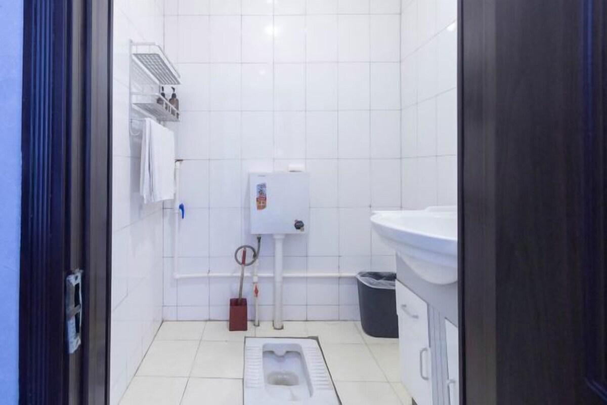 A small, clean bathroom with a toilet, sink, and storage shelves.