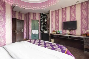 A hotel room with a bed, a television, a desk, and a bathroom door. - Hongfu Business Rooms (Panshi)