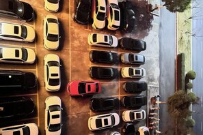 A parking lot with multiple rows of cars.
