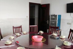 A conference room with a round table, chairs, and a television mounted on the wall. - JUNLAISHUN HOTE (Ruijin)