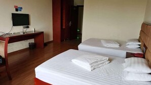 A hotel room with two beds, a desk, and a television. - JUNLAISHUN HOTE (Ruijin)