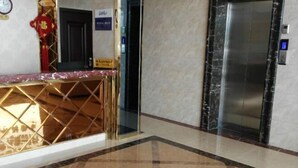 A hotel lobby with a reception desk, a marble floor, and an elevator. - JUNLAISHUN HOTE (Ruijin)