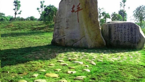 A large stone monument with inscriptions, surrounded by a grassy area with patterned stone paving. - JUNLAISHUN HOTE (Ruijin)