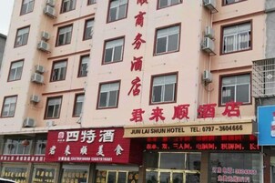 Un hotel con varios pisos, unidades de aire acondicionado y un cartel que indica 'JUN LAI SHUN HOTEL'.