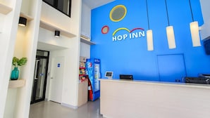 Un mostrador de recepción con una pared azul y un letrero que dice 'HOP INN'.