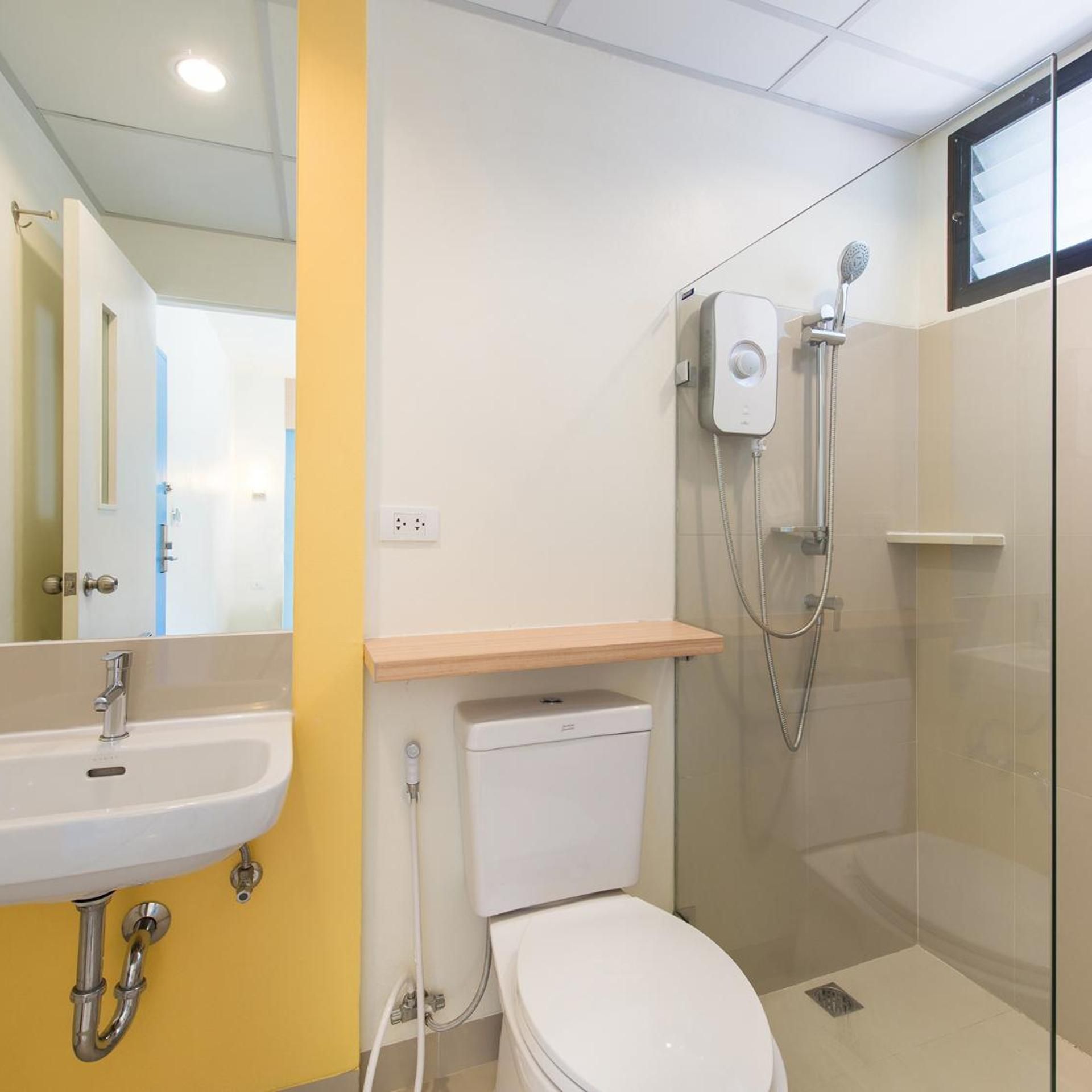 A bathroom with a toilet, sink, and shower.