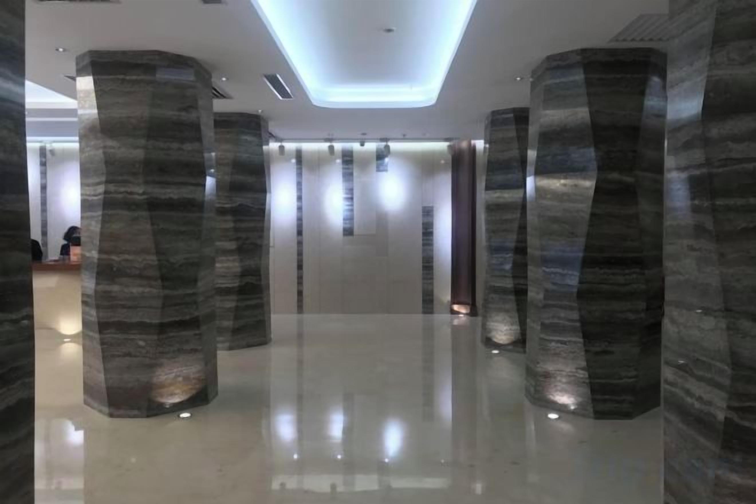 A modern interior with tall, cylindrical columns and a polished floor.
