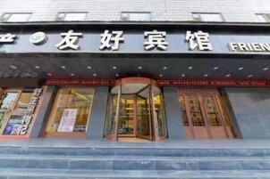 Un edificio con un cartel que dice '友好宾馆' y 'FRIENDLY HOTEL' en inglés.