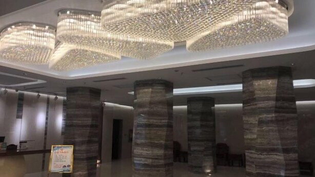 Un interior moderno con amplias columnas cilíndricas y una lámpara araña grande y elaborada.