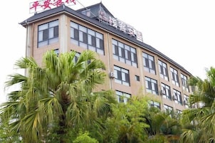 Un edificio de hotel de varios pisos con techo plano y numerosas ventanas.