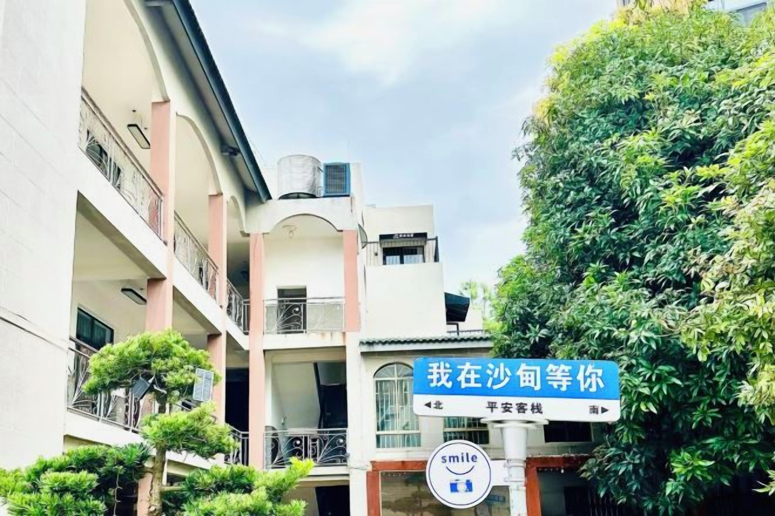 A multi-story building with balconies and a sign indicating a location.