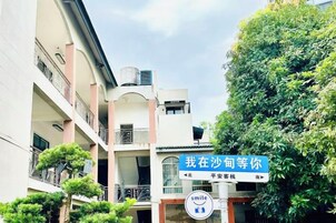Un edificio de varios pisos con balcones y un cartel que indica un lugar.