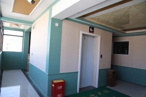 A hallway with a door marked '6w' and a trash bin.