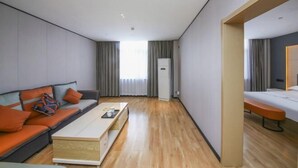 Une chambre d’hôtel moderne équipée d’un canapé, d’une table basse, d’un lit et d’un bureau.
